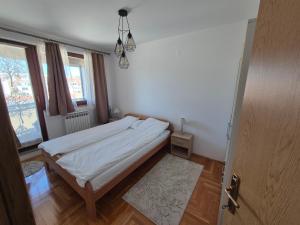 a small bedroom with a bed and a window at Apartman Dobrinja in Sarajevo