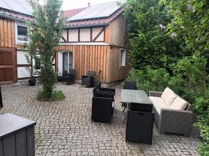 a patio with a table and chairs and a house at Franks kleines Bauernhaus in Dresden in Dresden