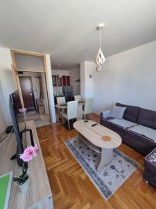 a living room with a couch and a table at Apartman Dobrinja in Sarajevo