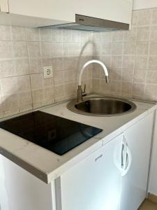 a kitchen with a sink and a white cabinet at Sara Apartments in Makarska +26 photos
