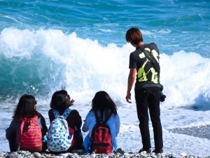un grupo de personas sentadas en la playa mirando al océano en Hai Yuansu 178 en Yanliau