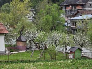 a playground in a yard with trees and houses at Apartman Vrbas in Donji Vakuf