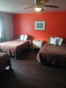 a hotel room with two beds and red walls at The Coalinga Motel in Coalinga