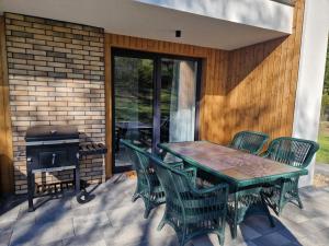 a patio with a table and chairs and a grill at Villa OLIVIA Ferienwohnung Misdroy Insel Ostsee in Wicko