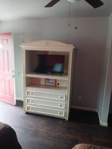 a entertainment center with a flat screen tv in a room at The Coalinga Motel in Coalinga