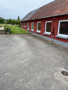 a parking lot in front of a red building at 40 kvm lejlighed in Kjellerup
