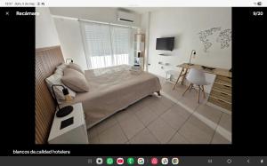 a bedroom with a bed and a desk with a computer at Luminoso y cálido atardecer in Ramos Mejía