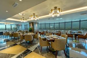 a restaurant with tables and chairs and windows at 1 Bedroom Apartment at Centaurus Mall in Islamabad