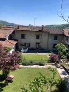 a large stone house with a yard with a dog at Casa La Barancina in Cittiglio