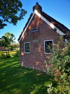 a brick building with a window in the grass at Trekkershut - Tiny House - Hikers cottage in Wijster +18 photos