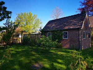 an old brick house sitting in a yard at Trekkershut - Tiny House - Hikers cottage in Wijster