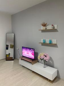 a living room with a tv and flowers on a table at Nestorovski House in Bitola