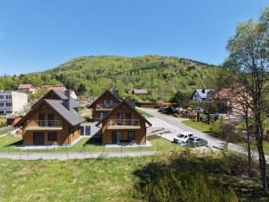 a home in a town with a mountain in the background at Apartamenty Ustronne Liściasta in Ustroń