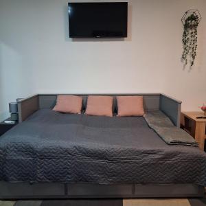 a bed with two pillows and a flat screen tv at Studio apartmani Atlantik in Nedelišće