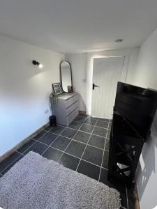 a bathroom with a mirror and a black tile floor at Double room container in Berkley
