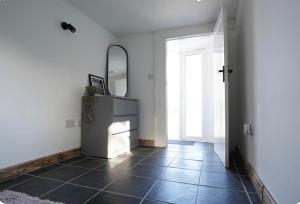 a hallway with a mirror and a tiled floor at Double room container in Berkley
