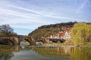 a bridge over a river with houses and trees at Anna's Waldchalet - FeWo Waldblick in Hannoversch Münden