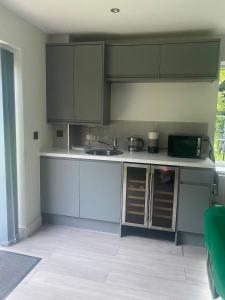 a kitchen with gray cabinets and a sink and a counter at Spacious and close to Gatwick in Crawley