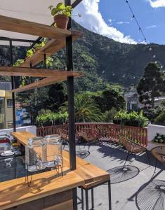 a patio with a table and chairs and a mountain at Crater Eruption Backpacker Hostel in Baños