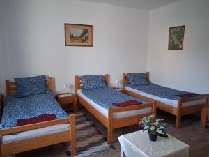 a room with three beds and a table at Gabriella Vendégház in Vadna