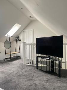 a flat screen tv sitting on a stand in a room at Spacious and close to Gatwick in Crawley