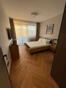 a bedroom with a bed and a wooden floor at Sofia Tech Park Apartments - Premium in Sofia +73 photos