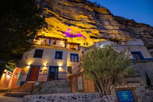 a house on the side of a mountain at night at XUQ Hotels Alaxara in Cubas