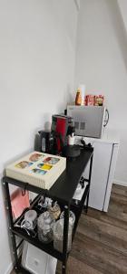 a black table in a room with a microwave at Chez Toi Ailleurs - Dinant in Dinant