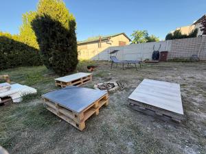 two picnic tables and a bench in a yard at Self-Check- New Home in Levice