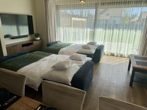 two beds in a room with a large window at Dom Port Orion Puck in Puck +26 photos