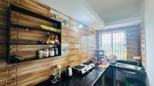 a kitchen with wooden walls and a stove and a sink at Si' Casa in Mandrem
