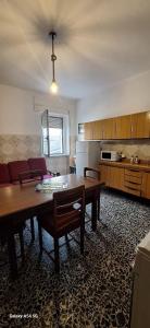 a living room with a table and a kitchen at B&B Sa Rocca Manna in Laerru