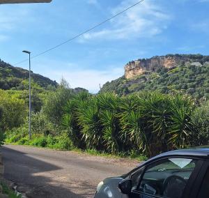 a car parked on the side of a road with a mountain at B&B Sa Rocca Manna in Laerru