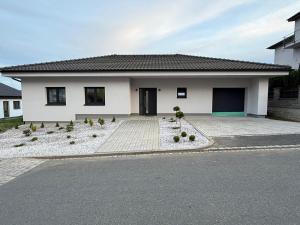 a white house with a driveway in front of it at Guesthouse in Rozvadov