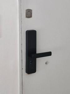 a black door handle on a white door at Luminoso y cálido atardecer in Ramos Mejía