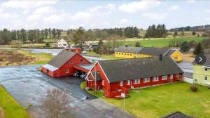 a group of red and yellow buildings in a field at Stayover Lista in Farsund
