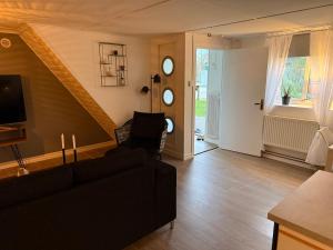 a living room with a black couch and a staircase at Villa Gul in beautiful Smygehamn in Smygehamn