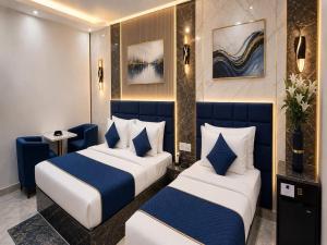 two beds in a room with blue and white at Hotel GRAN-SOL Near DELHI Airport in New Delhi