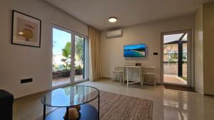 a living room with a glass table and a desk at Maki Exclusive Apartments in Hvar