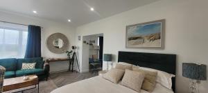 a bedroom with a bed and a couch and a table at Atlantic Way Suites Doonbeg Co Clare in Doonbeg