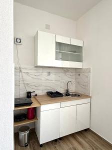 a kitchen with white cabinets and a sink at Apartment Belase in Plav