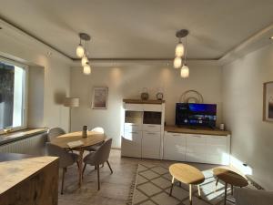 a living room with a table and chairs and a tv at DORMAR II Apartament in Wałbrzych