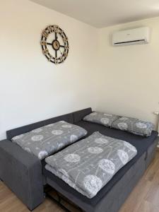 a living room with a couch and a clock on the wall at Apartma Luvita in Golnik +28 photos