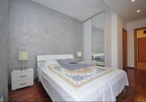 a bedroom with a large white bed and a mirror at Seaside Apartments Petrovac in Petrovac na Moru