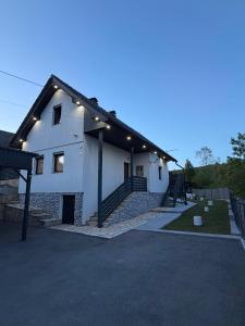 a white house with lights on the side of it at Apartments Sertic 4 stars in Poljanak