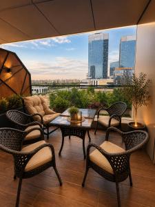 a patio with chairs and a table and a view of a city at NestOne - Apartment hotels in Tashkent