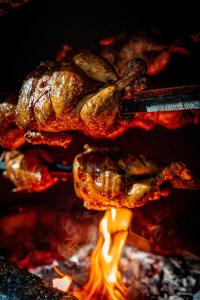 a group of food cooking on a grill with flames at Foresta Yala in Tissamaharama