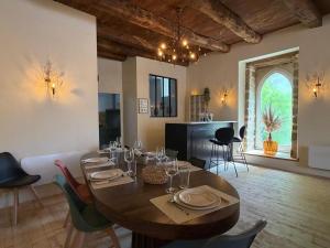 a dining room with a wooden table and chairs at Le Gîte du Prieuré in Josselin