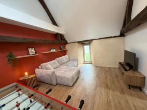 a living room with a couch and a television at Le Gîte du Prieuré in Josselin