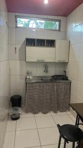 a small kitchen with a sink and a window at HOSTEL Divinópolis in Divinópolis